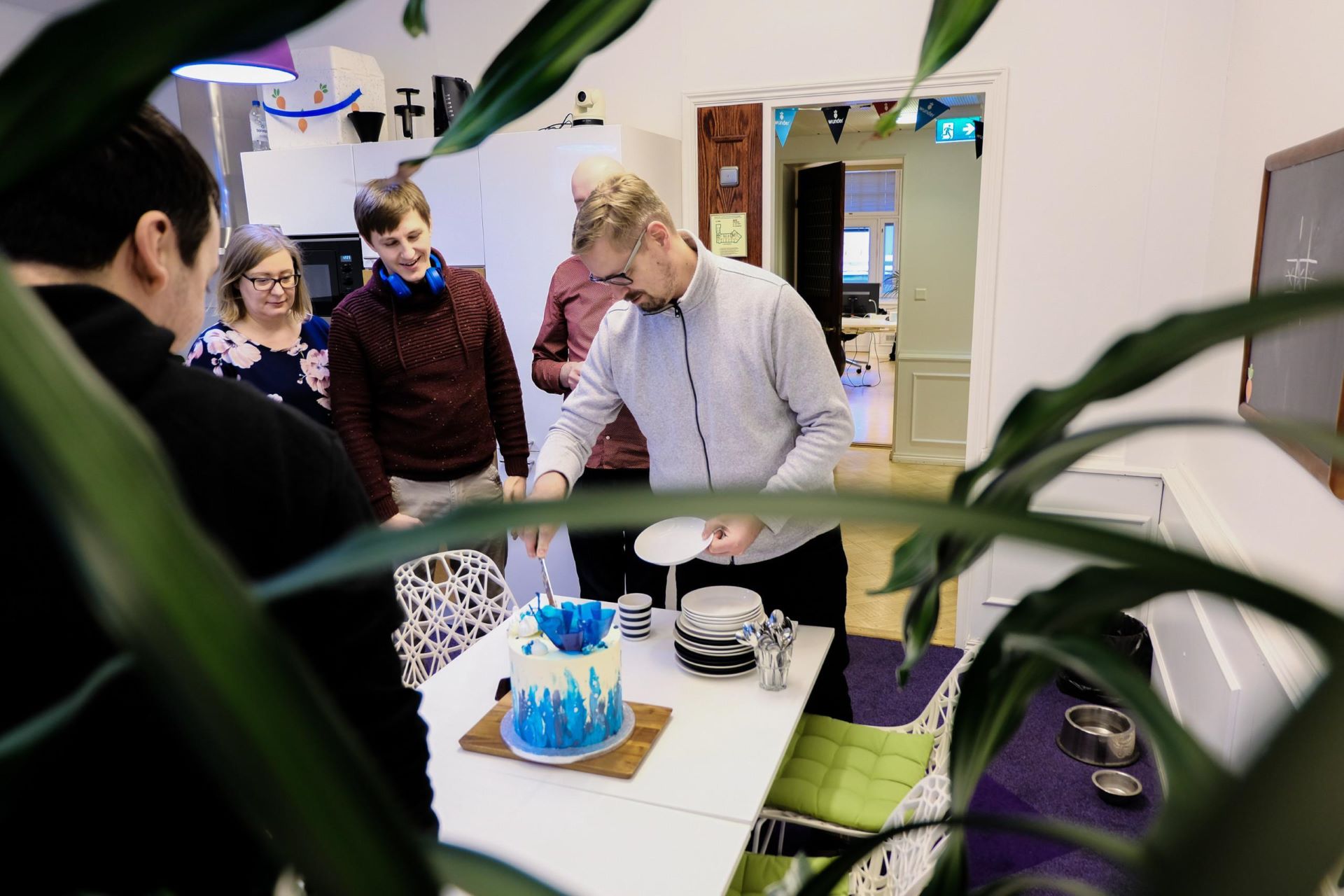 Mearra people around a Drupal-themed cake at Mearra Helsinki office's kitchen.