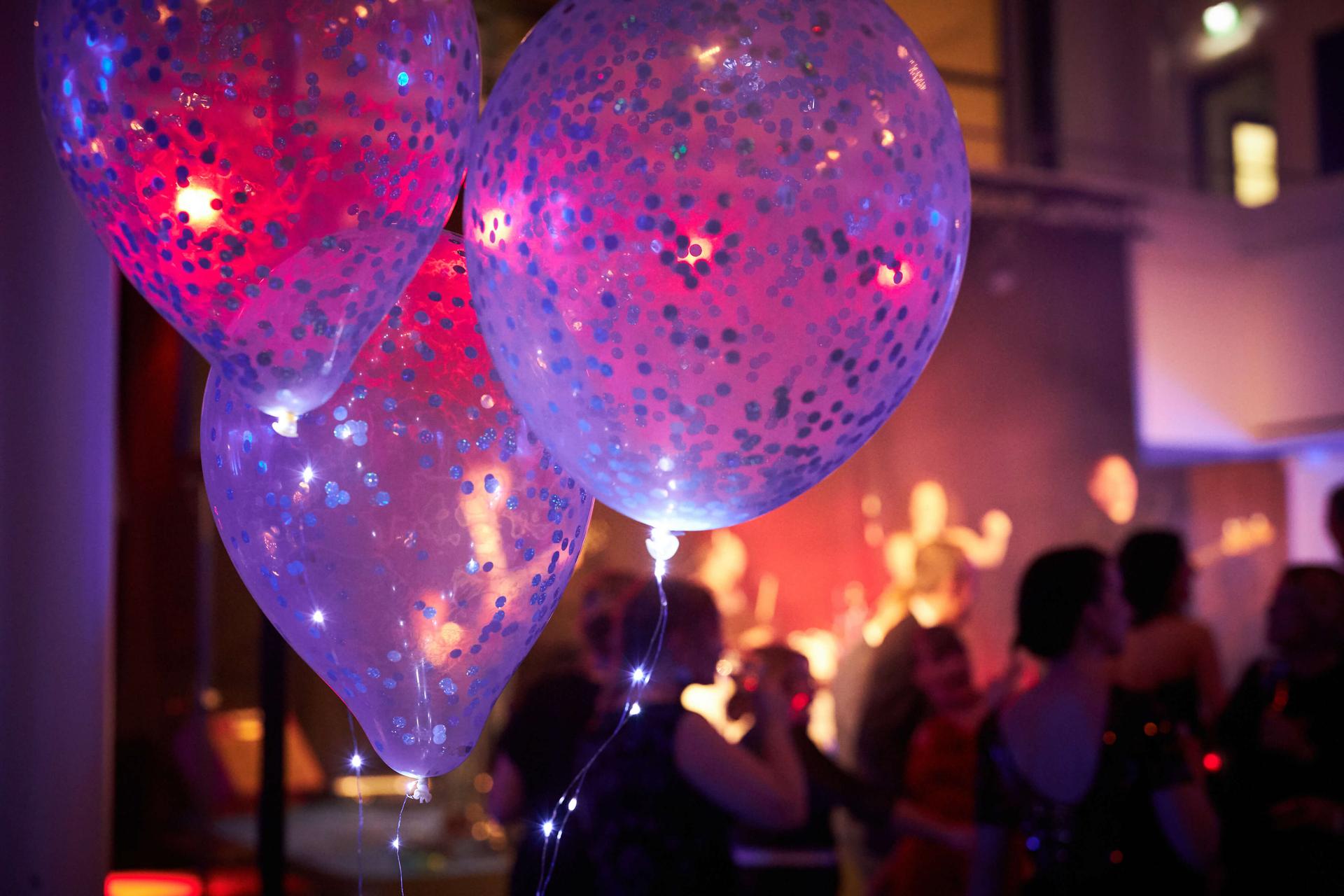 Event hall with three balloons in purple light