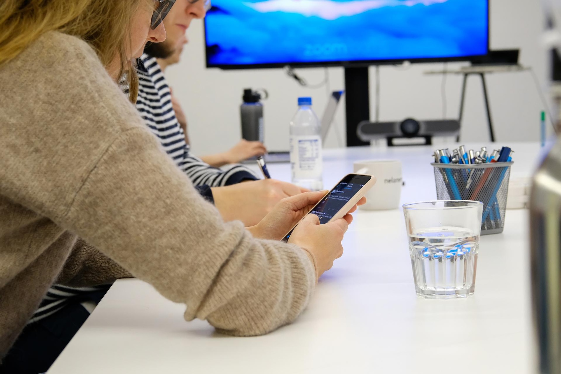 Two people working together, another one is holding a phone