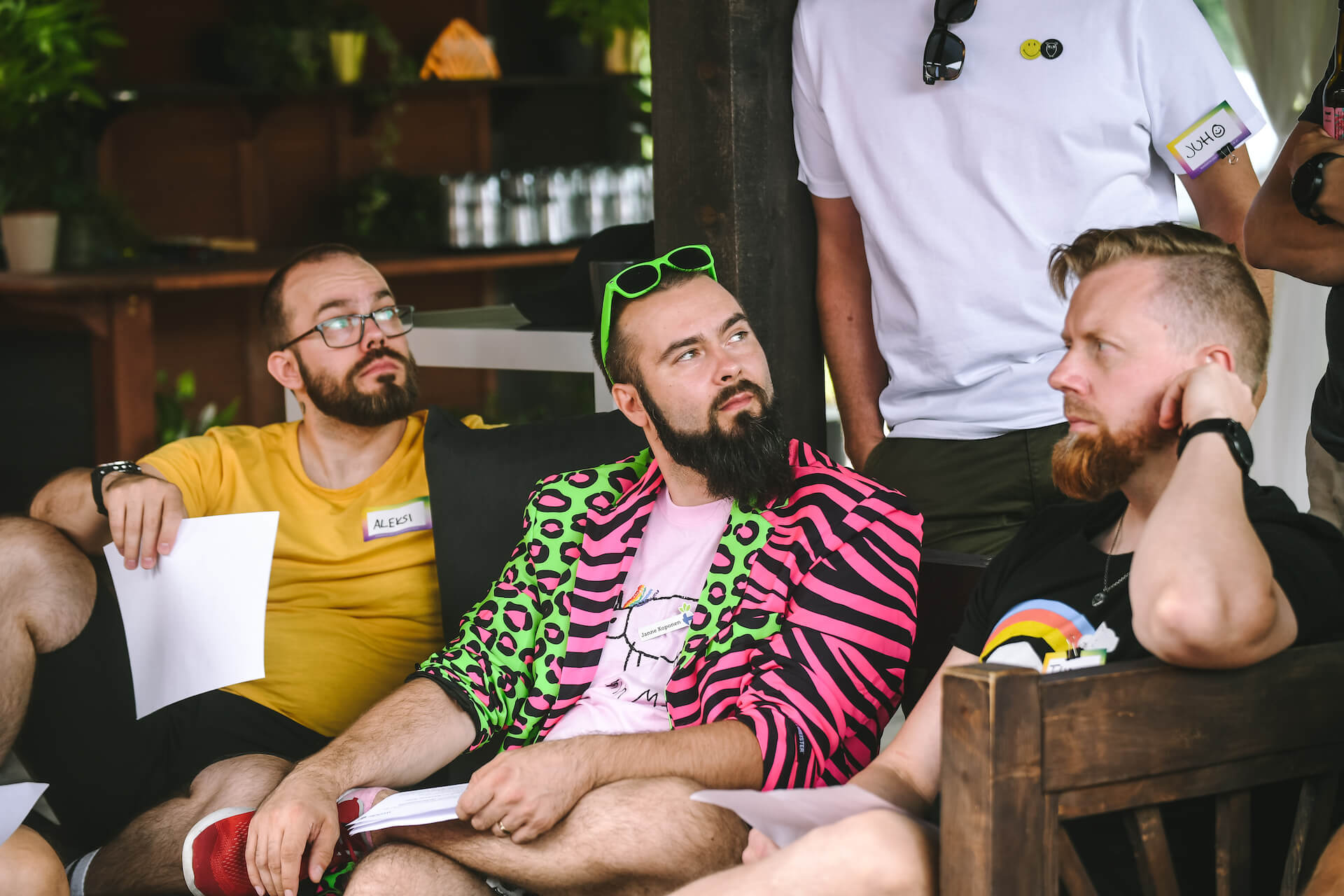 Three people in colorful clothes sitting on a bench