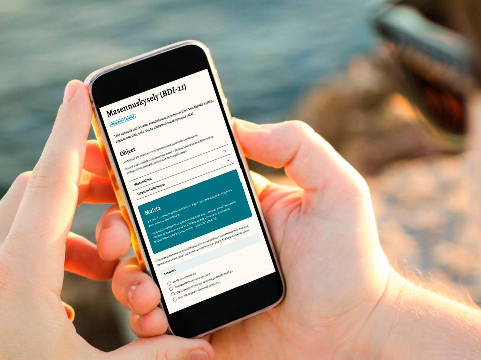 A person holding a phone with the mielenterveystalo.fi open on screen