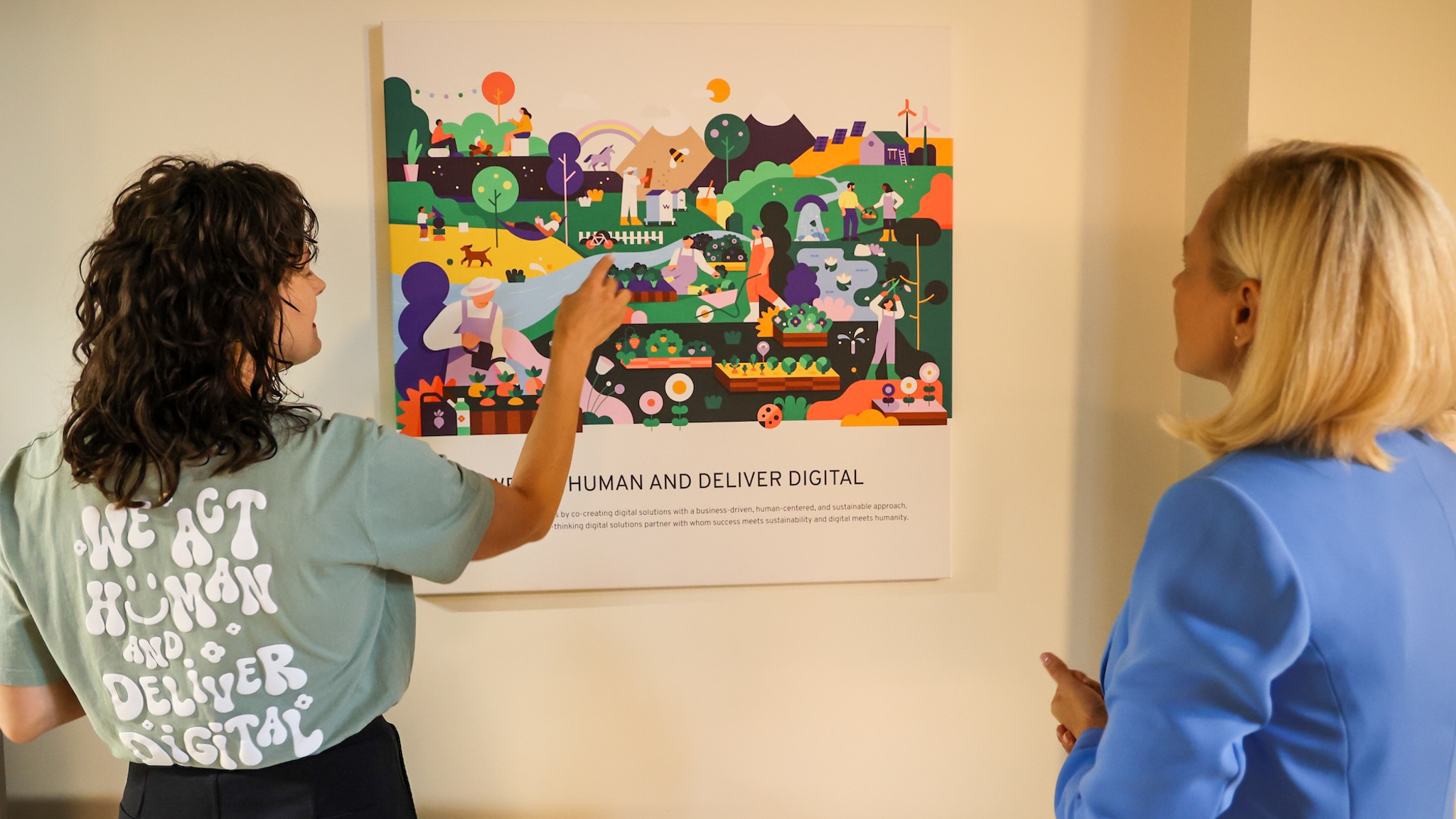 Two persons standing with a back, one pointing at a painting, the other watching