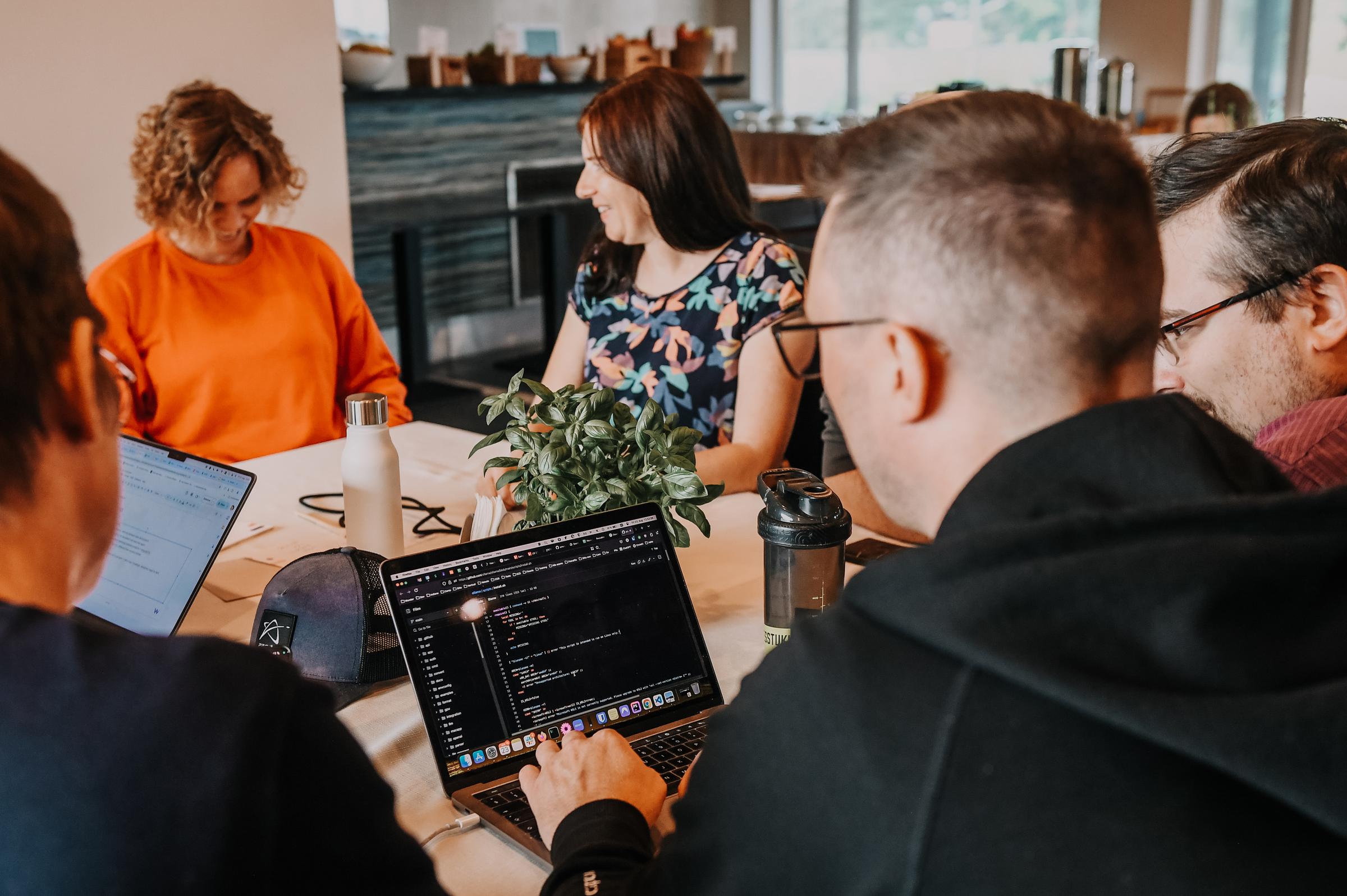 People working together around a table with their laptops